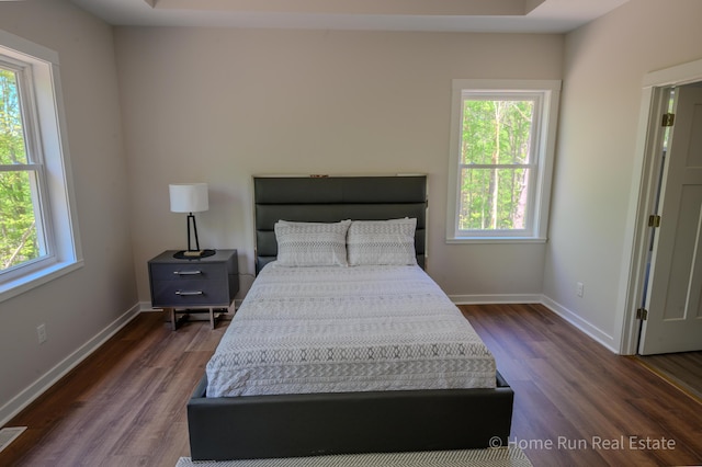 bedroom with dark wood finished floors and baseboards