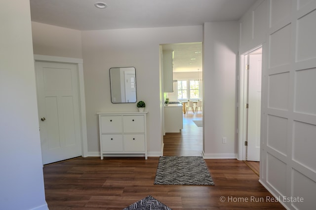 hallway featuring dark wood finished floors, baseboards, and recessed lighting