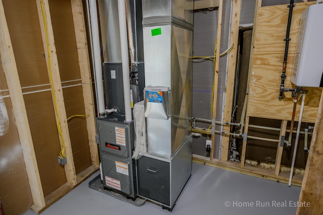 utility room with heating unit and water heater