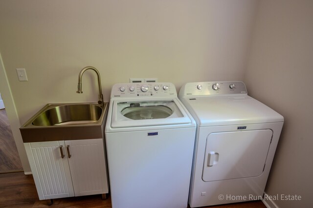 clothes washing area with washer and dryer, cabinet space, and dark wood-type flooring