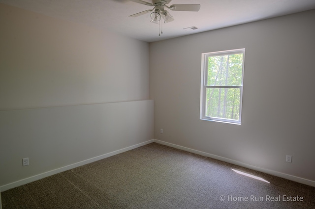 carpeted spare room featuring healthy amount of natural light, a ceiling fan, and baseboards