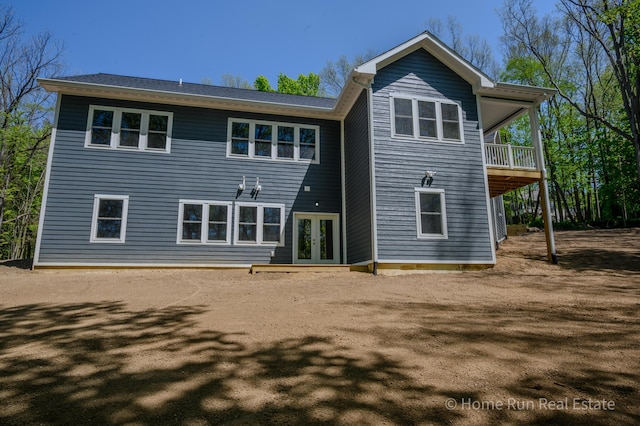 rear view of property with french doors and a balcony