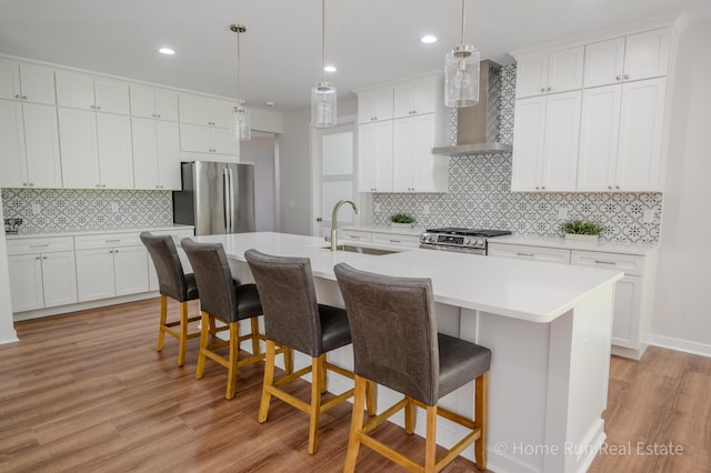 8828 Division Ave S, Byron Center, MI 49315 - kitchen with a sink, wall chimney range hood, appliances with stainless steel finishes, tasteful backsplash, and light wood finished floors