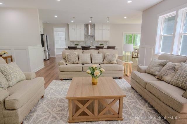 8828 Division Ave S, Byron Center, MI 49315 - living room featuring light wood-style floors, recessed lighting, a decorative wall, and a wainscoted wall