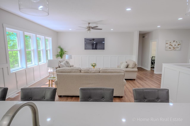 8828 Division Ave S, Byron Center, MI 49315 - living room with wood finished floors, a ceiling fan, recessed lighting, a wainscoted wall, and a decorative wall