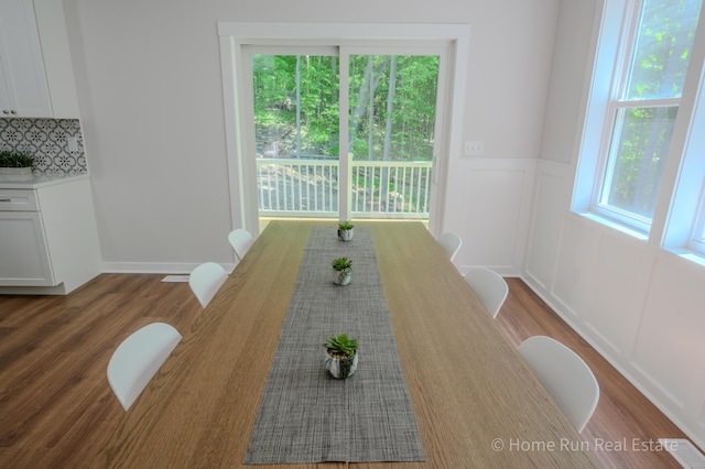 8828 Division Ave S, Byron Center, MI 49315 - unfurnished dining area with wood finished floors, wainscoting, and a decorative wall