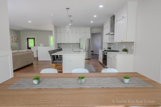 8828 Division Ave S, Byron Center, MI 49315 - kitchen with stainless steel appliances, wall chimney exhaust hood, white cabinetry, backsplash, and recessed lighting