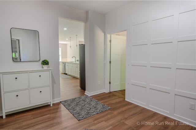 8828 Division Ave S, Byron Center, MI 49315 - bedroom with wood finished floors, freestanding refrigerator, a sink, baseboards, and ensuite bath