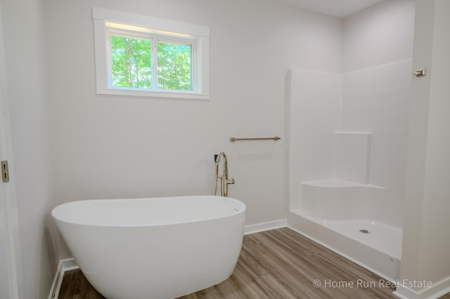 8828 Division Ave S, Byron Center, MI 49315 - full bath featuring wood finished floors, baseboards, and a freestanding tub