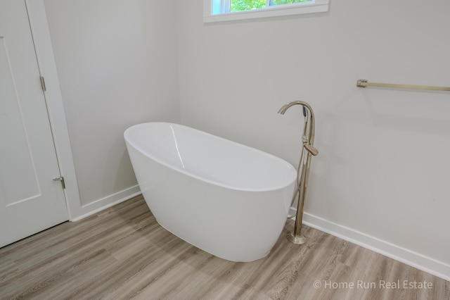 8828 Division Ave S, Byron Center, MI 49315 - full bath with wood finished floors, a freestanding tub, and baseboards