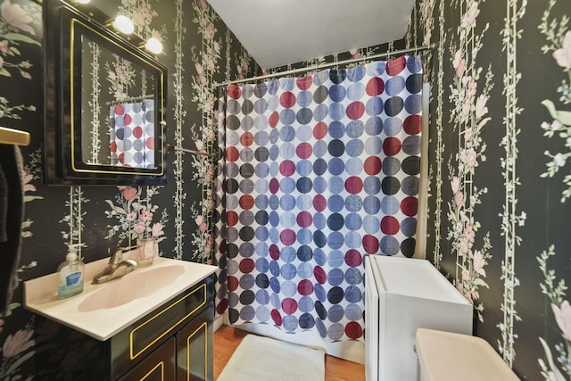 555 S Lakeside Dr, Michigan Center, MI 49254 - full bathroom with wallpapered walls, vanity, a shower with curtain, wood finished floors, and toilet