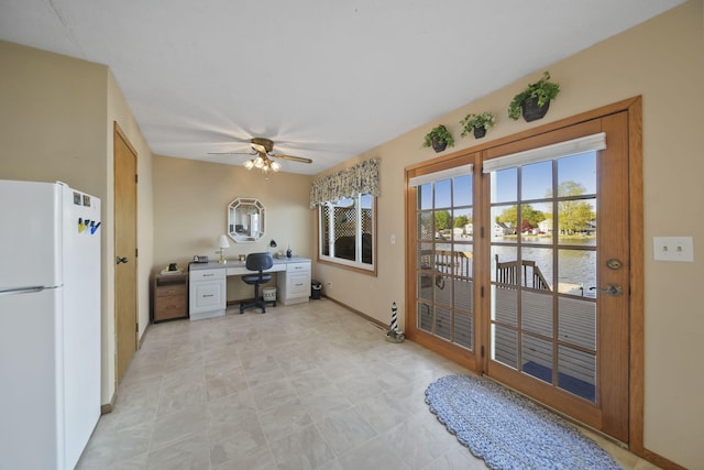 555 S Lakeside Dr, Michigan Center, MI 49254 - kitchen with freestanding refrigerator, baseboards, a desk, a ceiling fan, and a water view