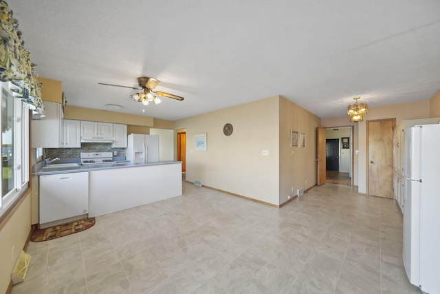 555 S Lakeside Dr, Michigan Center, MI 49254 - kitchen featuring white appliances, a chandelier, a peninsula, ceiling fan, and tasteful backsplash