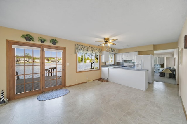 555 S Lakeside Dr, Michigan Center, MI 49254 - kitchen featuring white appliances, a peninsula, a ceiling fan, white cabinetry, and tasteful backsplash