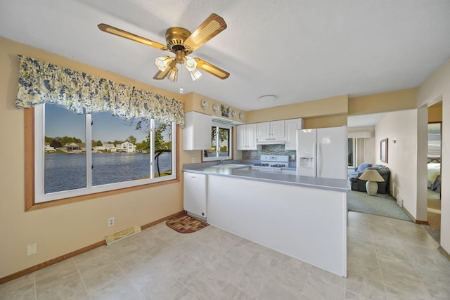 555 S Lakeside Dr, Michigan Center, MI 49254 - kitchen featuring white appliances, a sink, under cabinet range hood, white cabinets, and a peninsula