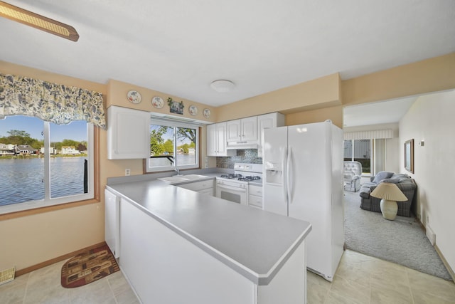 555 S Lakeside Dr, Michigan Center, MI 49254 - kitchen with white appliances, white cabinetry, a sink, a peninsula, and under cabinet range hood