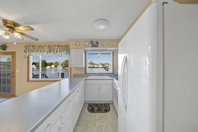 555 S Lakeside Dr, Michigan Center, MI 49254 - kitchen with white appliances, white cabinets, a sink, and healthy amount of natural light