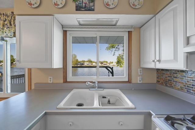 555 S Lakeside Dr, Michigan Center, MI 49254 - kitchen featuring a sink, range, white cabinetry, a water view, and light countertops