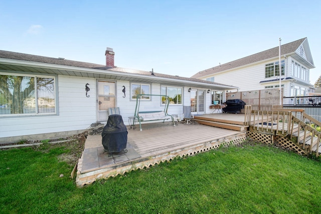 555 S Lakeside Dr, Michigan Center, MI 49254 - rear view of property featuring a chimney, a lawn, and a wooden deck