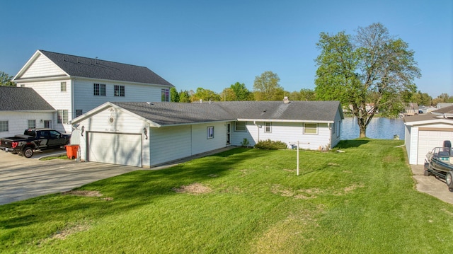 555 S Lakeside Dr, Michigan Center, MI 49254 - back of property featuring an attached garage, a lawn, and driveway