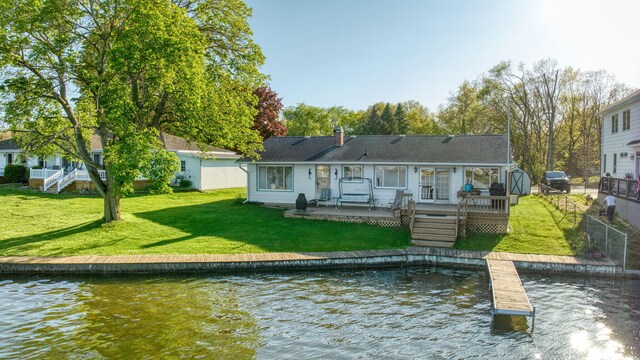 555 S Lakeside Dr, Michigan Center, MI 49254 - rear view of property featuring a deck with water view, a yard, and a chimney