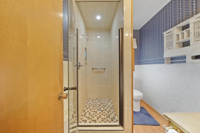555 S Lakeside Dr, Michigan Center, MI 49254 - full bathroom with wallpapered walls, a shower stall, toilet, and wood finished floors