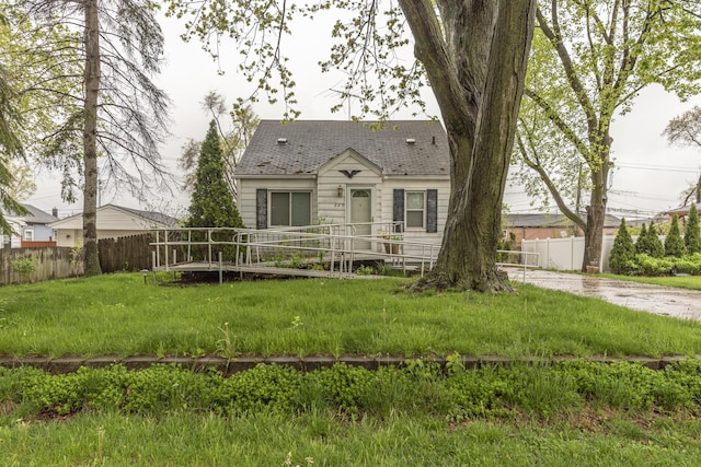 885 Hawthorne Ave, Ypsilanti, MI 48198 - view of front facade with fence, a wooden deck, and roof with shingles