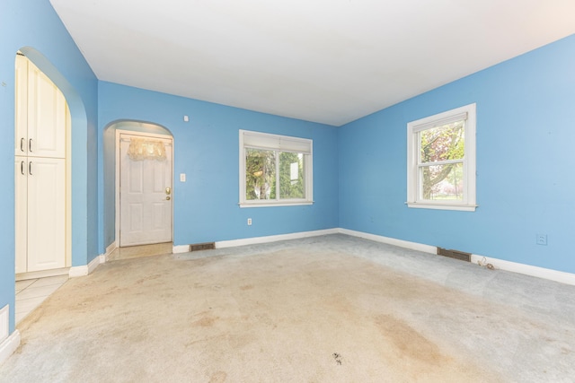 885 Hawthorne Ave, Ypsilanti, MI 48198 - spare room with arched walkways, carpet flooring, and healthy amount of natural light