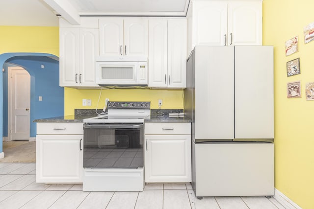 885 Hawthorne Ave, Ypsilanti, MI 48198 - kitchen with white appliances, white cabinets, dark countertops, and light tile patterned floors