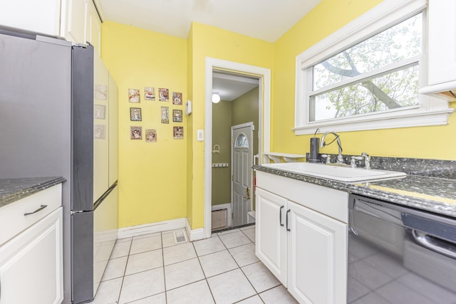 885 Hawthorne Ave, Ypsilanti, MI 48198 - kitchen with dishwashing machine, freestanding refrigerator, a sink, white cabinetry, and light tile patterned floors