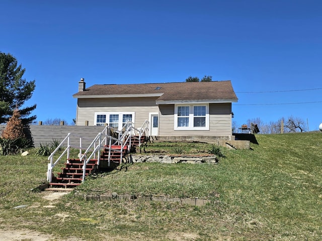rear view of house featuring stairs, a chimney, a deck, and a yard