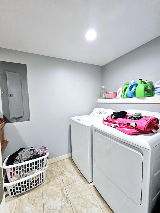 clothes washing area with electric panel, washer and clothes dryer, and baseboards
