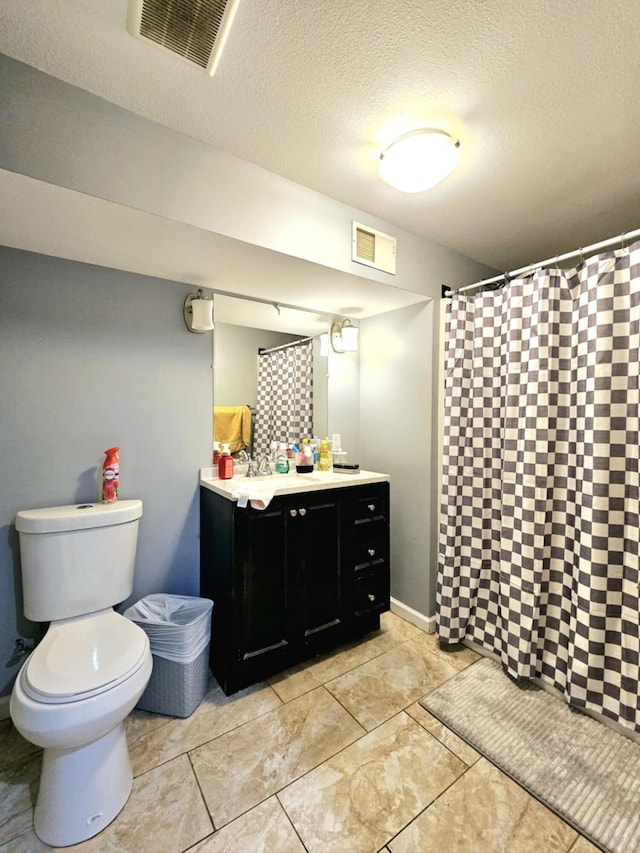 bathroom with toilet, vanity, a textured ceiling, and a shower with shower curtain