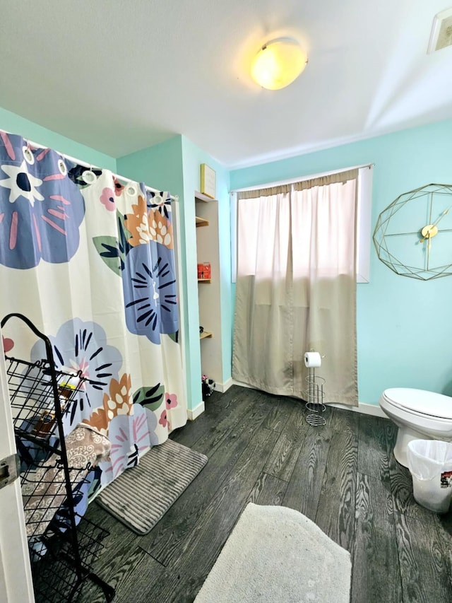bathroom featuring wood finished floors, toilet, baseboards, and curtained shower