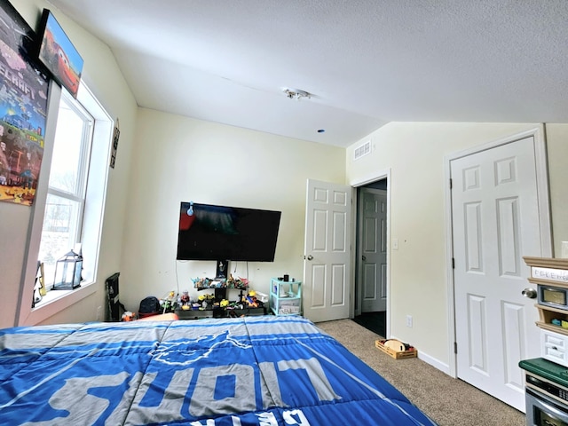 carpeted bedroom with lofted ceiling