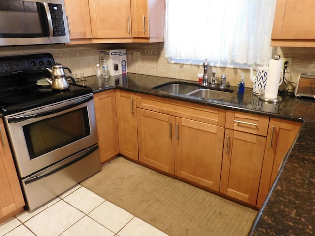 5244 Folkstone Dr, Troy, MI 48085 - kitchen with stainless steel appliances, a sink, decorative backsplash, dark stone counters, and light tile patterned floors