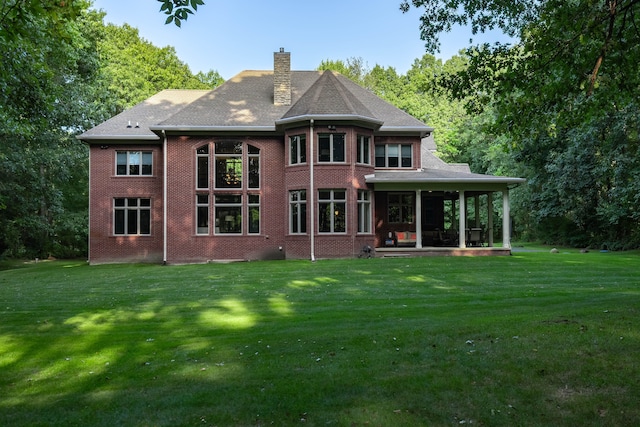 8307 Granite Ct, Dexter, MI 48130 - back of house featuring a lawn, a chimney, brick siding, and a patio