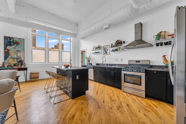 2843 E Grand Blvd Unit 9, Detroit, MI 48211 - kitchen with stainless steel appliances, dark cabinets, range hood, open shelves, and a kitchen bar