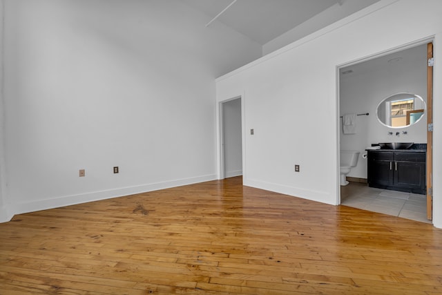 2843 E Grand Blvd Unit 9, Detroit, MI 48211 - empty room with light wood-style floors, a towering ceiling, and baseboards