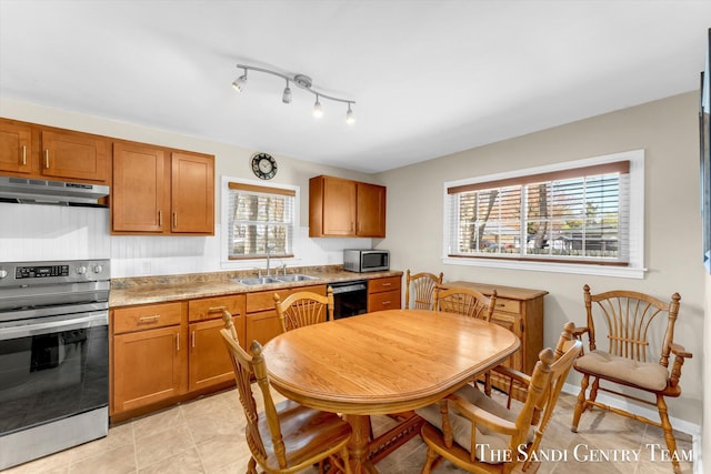 kitchen featuring under cabinet range hood, stainless steel appliances, a sink, brown cabinets, and light countertops