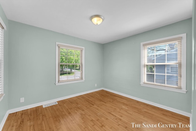empty room featuring wood finished floors and baseboards