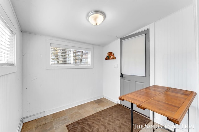 dining room featuring baseboards, healthy amount of natural light, and stone finish floors
