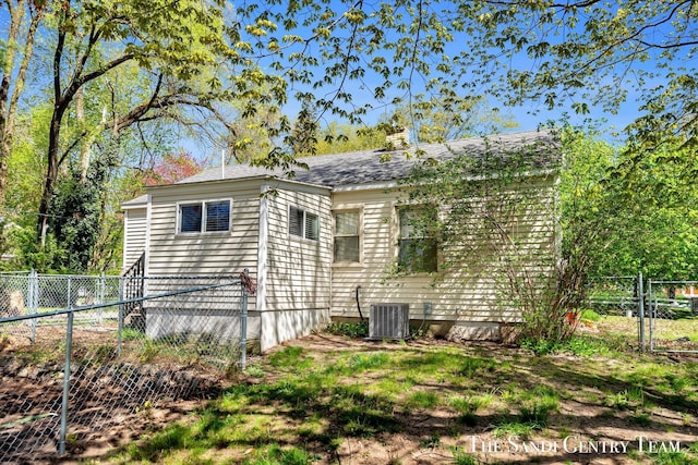 view of home's exterior with fence, a gate, a chimney, cooling unit, and roof with shingles