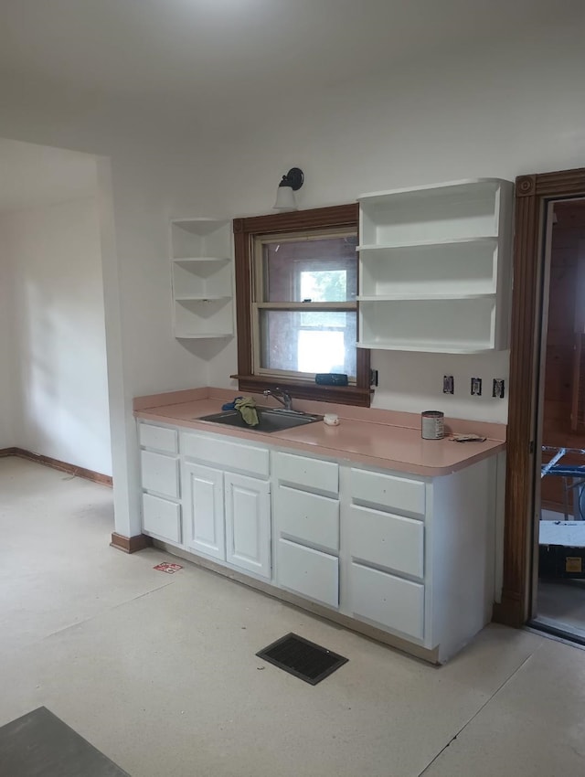 318 W King St, Owosso, MI 48867 - kitchen with open shelves, white cabinets, a sink, and light countertops