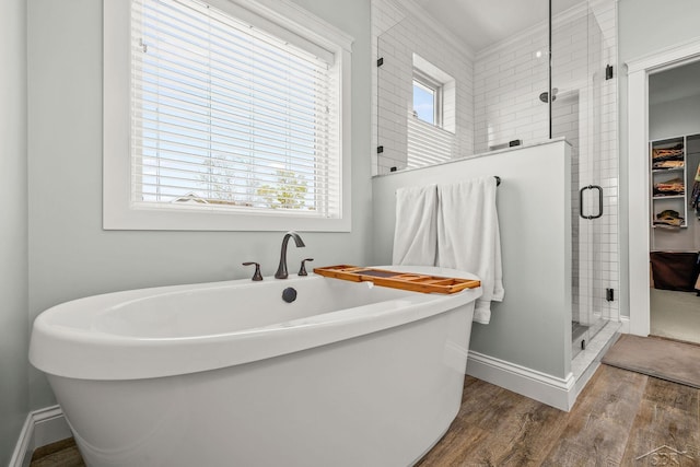 5353 N Graham Rd, Freeland, MI 48623 - bathroom with wood finished floors, a shower stall, baseboards, a freestanding bath, and crown molding