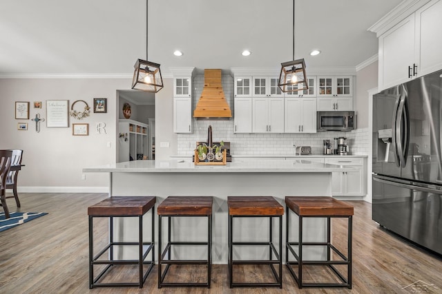 5353 N Graham Rd, Freeland, MI 48623 - kitchen featuring appliances with stainless steel finishes, tasteful backsplash, a kitchen breakfast bar, custom exhaust hood, and crown molding