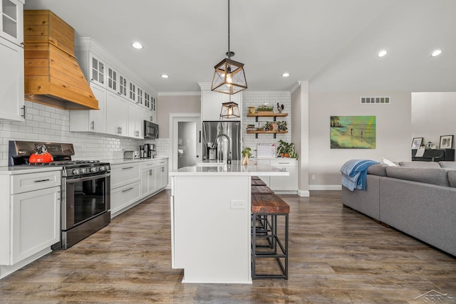 5353 N Graham Rd, Freeland, MI 48623 - kitchen featuring stainless steel appliances, custom range hood, open floor plan, backsplash, and a breakfast bar