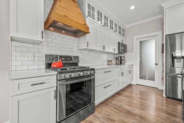 5353 N Graham Rd, Freeland, MI 48623 - kitchen featuring stainless steel appliances, custom exhaust hood, light countertops, ornamental molding, and white cabinetry