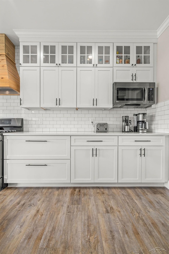 5353 N Graham Rd, Freeland, MI 48623 - kitchen featuring stainless steel appliances, white cabinetry, premium range hood, and ornamental molding