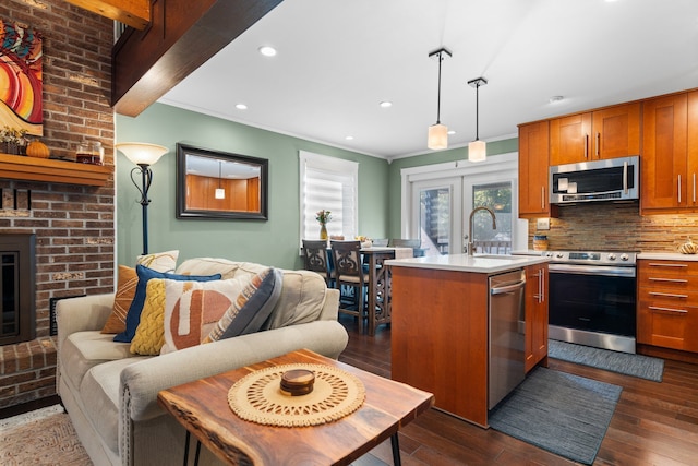 kitchen featuring appliances with stainless steel finishes, a sink, light countertops, backsplash, and brown cabinets